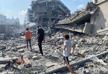 Palestinians inspect the damage following an Israeli airstrike on the El-Remal area in Gaza City