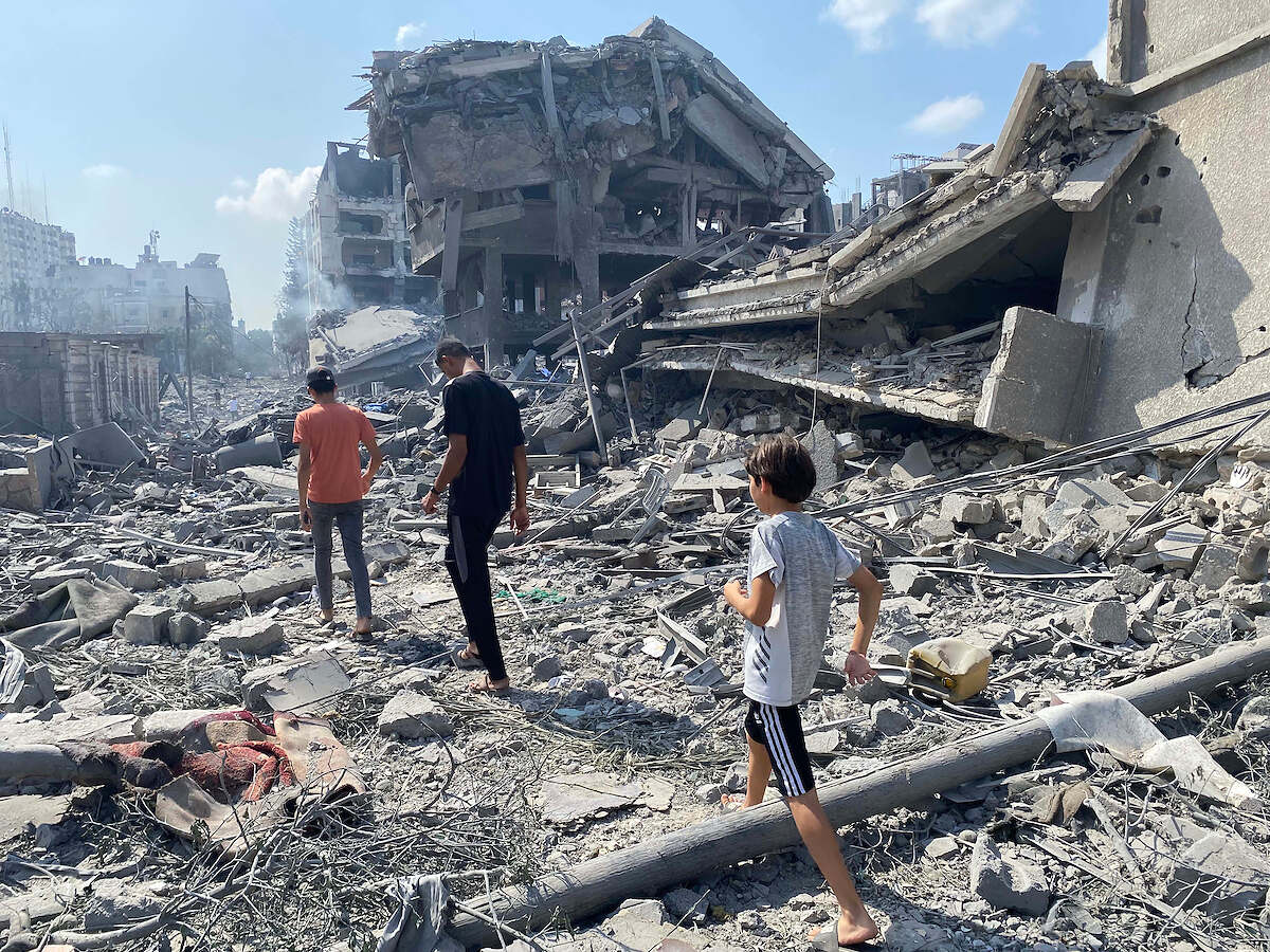 Palestinians inspect the damage following an Israeli airstrike on the El-Remal area in Gaza City